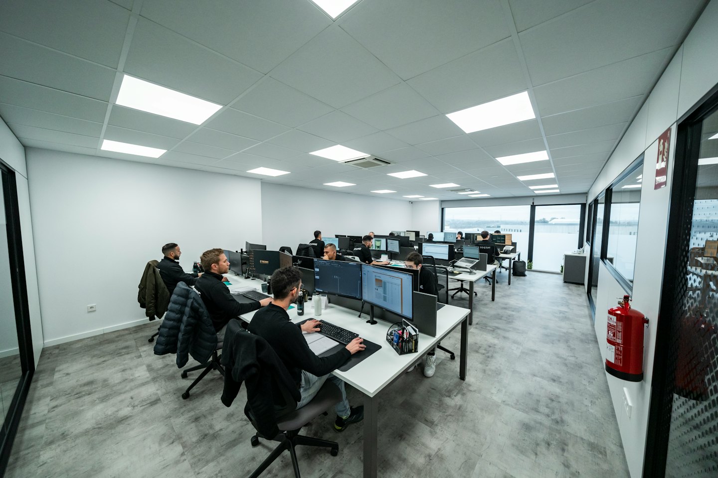 Vielfältige Männer arbeiten an Computern in einem modernen Großraumbüro.